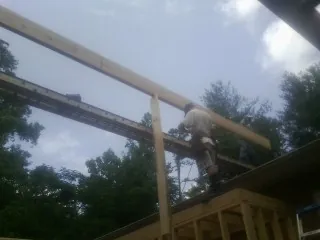 Carpenter setting a ridge beam over a new addition frame — Ice Dam Removal by Roofing Brothers in Slaughters