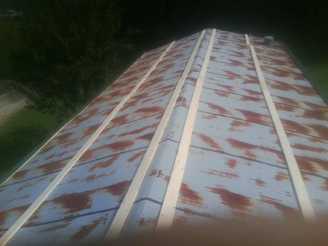 Rusted metal roof panels with new wood purlins before replacement — Storm Damage Roof Repair in Slaughters by Roofing Brothers