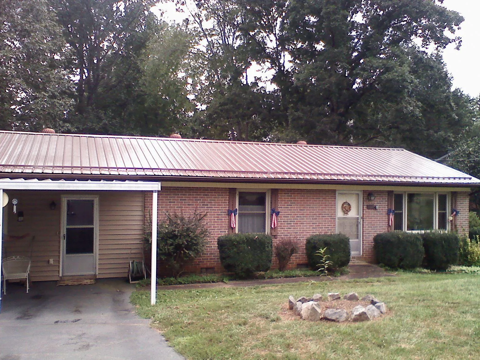 Bronze metal roof and carport on a brick ranch home — Roof Repair work by our crew in Slaughters